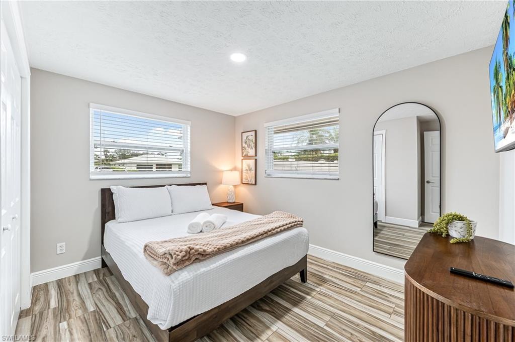 Bedroom featuring a closet, light hardwood / wood-style flooring, and a textured ceiling