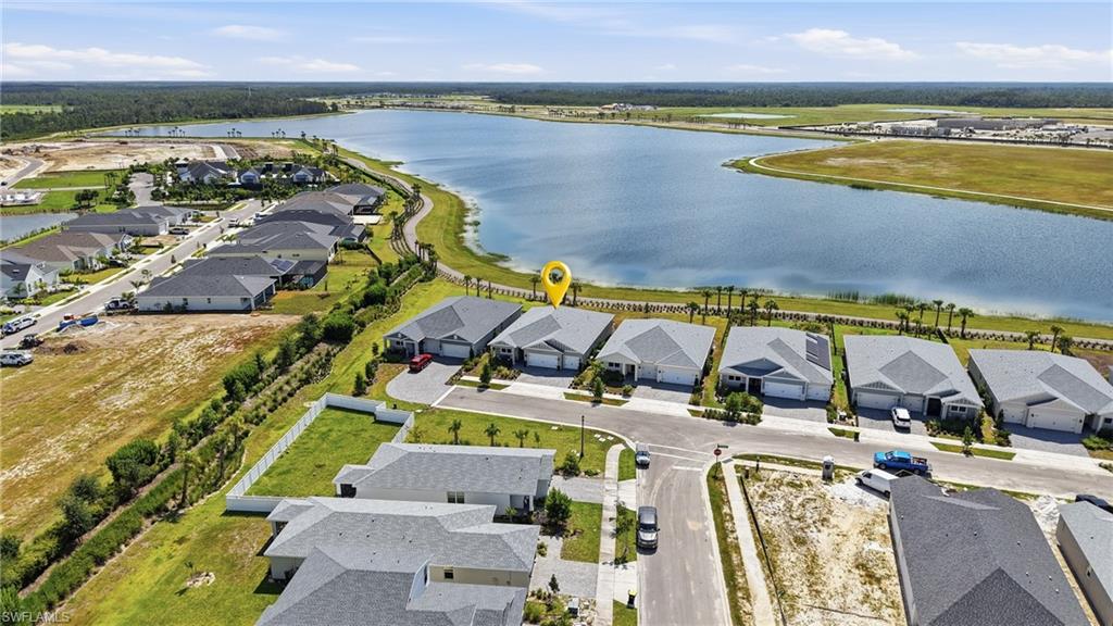 Lakeside community featuring single-story homes with attached garages, paved driveways, and manicured landscaping