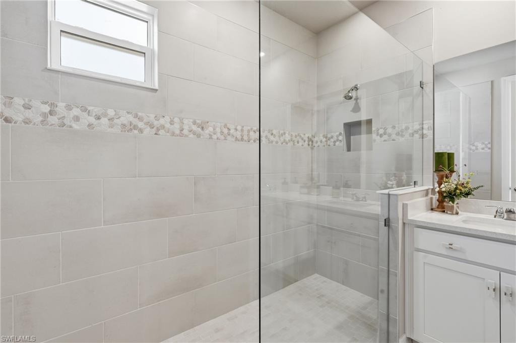 Glass-enclosed shower with a recessed niche and integrated shower bench