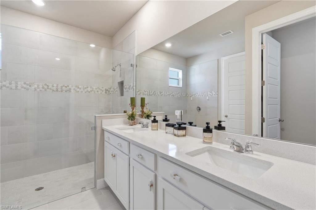 Double vanity with white cabinetry and integrated sinks set into a light-toned countertop