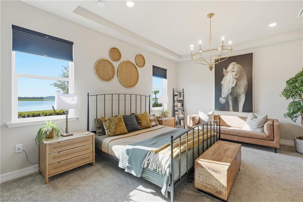 Recessed lighting, large windows with water scenery, tray ceiling, and a gold-tone chandelier