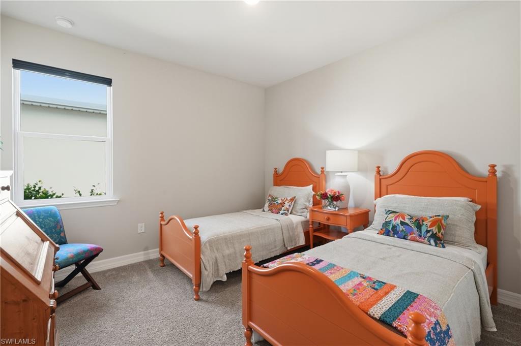 Plush carpet flooring, light gray wall finishes, a single-pane window with roller shade, and an overhead recessed light fixture