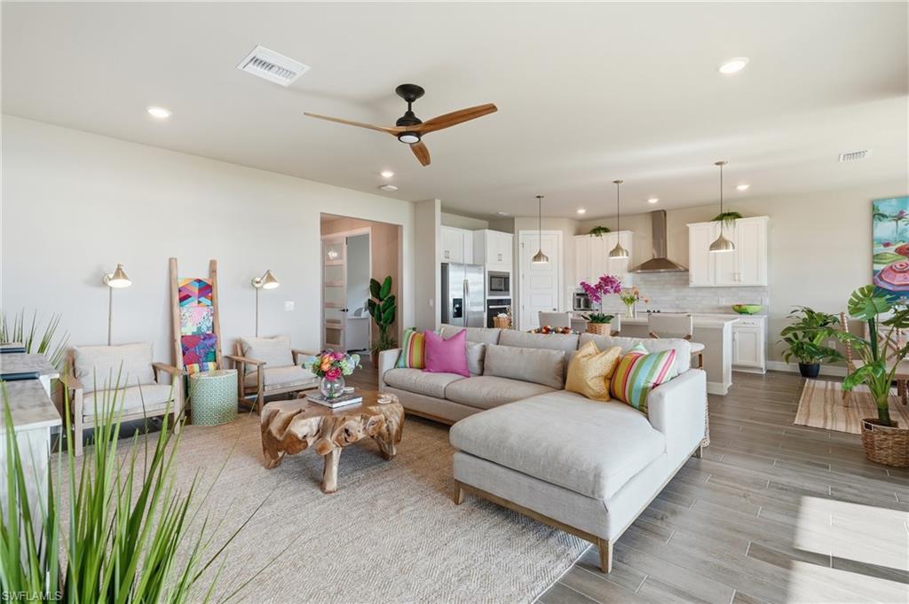 Recessed lighting, ceiling fan, wood-finish flooring, white cabinetry, and stainless steel appliances