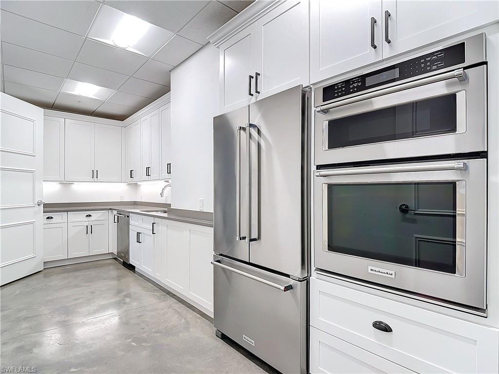 Kitchen with white cabinetry, stainless steel appliances, a paneled ceiling, and sink