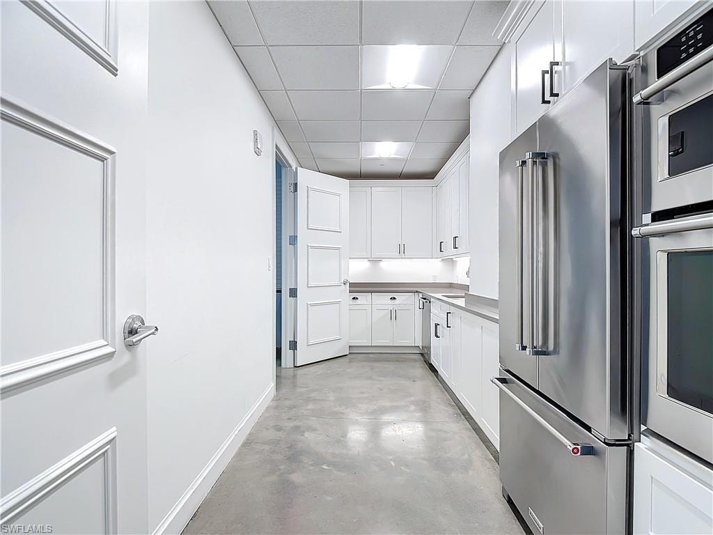 Kitchen featuring white cabinetry, a paneled ceiling, and stainless steel appliances
