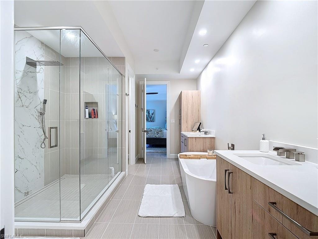 Bathroom featuring vanity, independent shower and bath, and tile patterned flooring