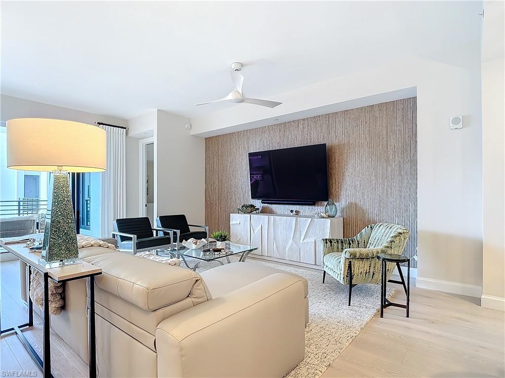 Living room with light wood-type flooring and ceiling fan