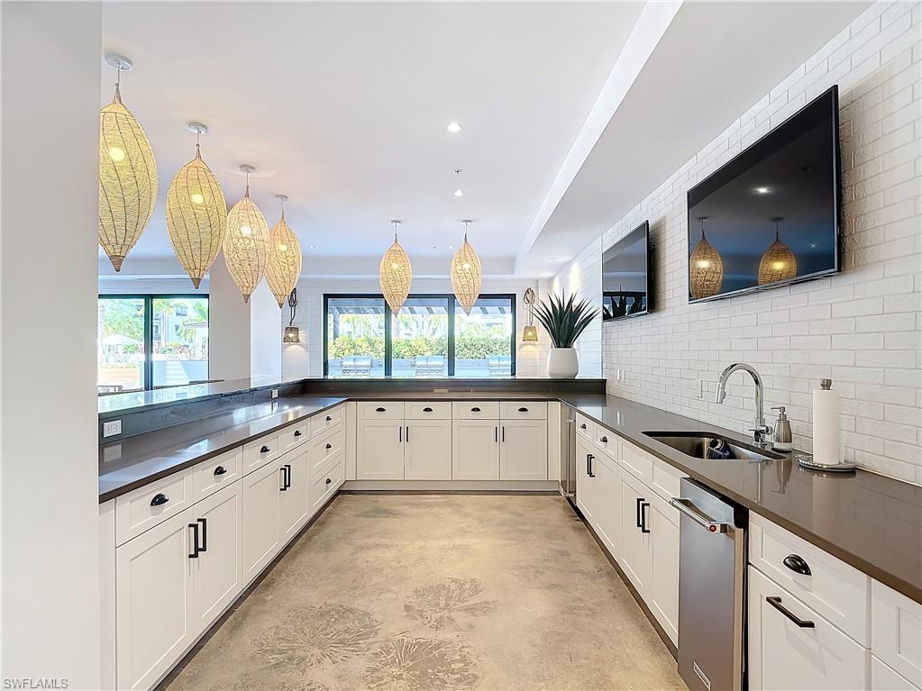 Kitchen featuring white cabinets, sink, a wealth of natural light, and pendant lighting