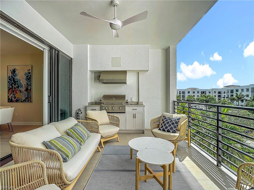 Balcony with an outdoor hangout area, ceiling fan, and grilling area