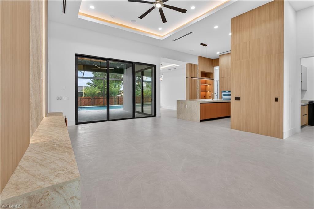 Open-concept living space featuring light-toned flooring, expansive sliding glass doors, and recessed lighting