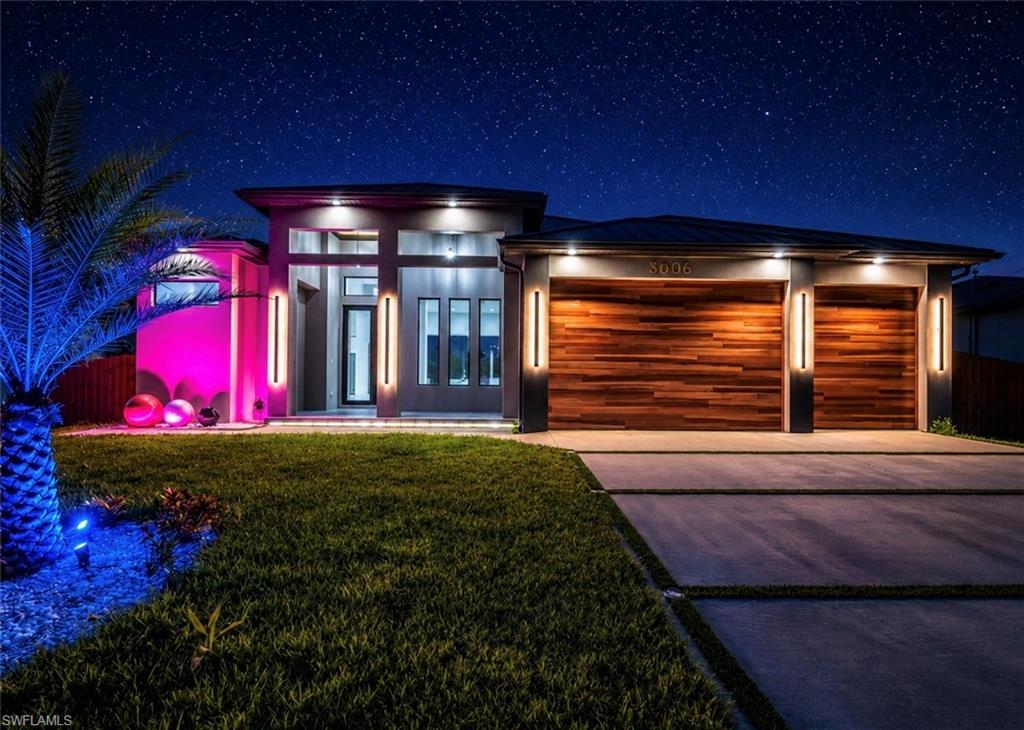 Modern facade featuring a prominent two-car garage with wood-finish doors