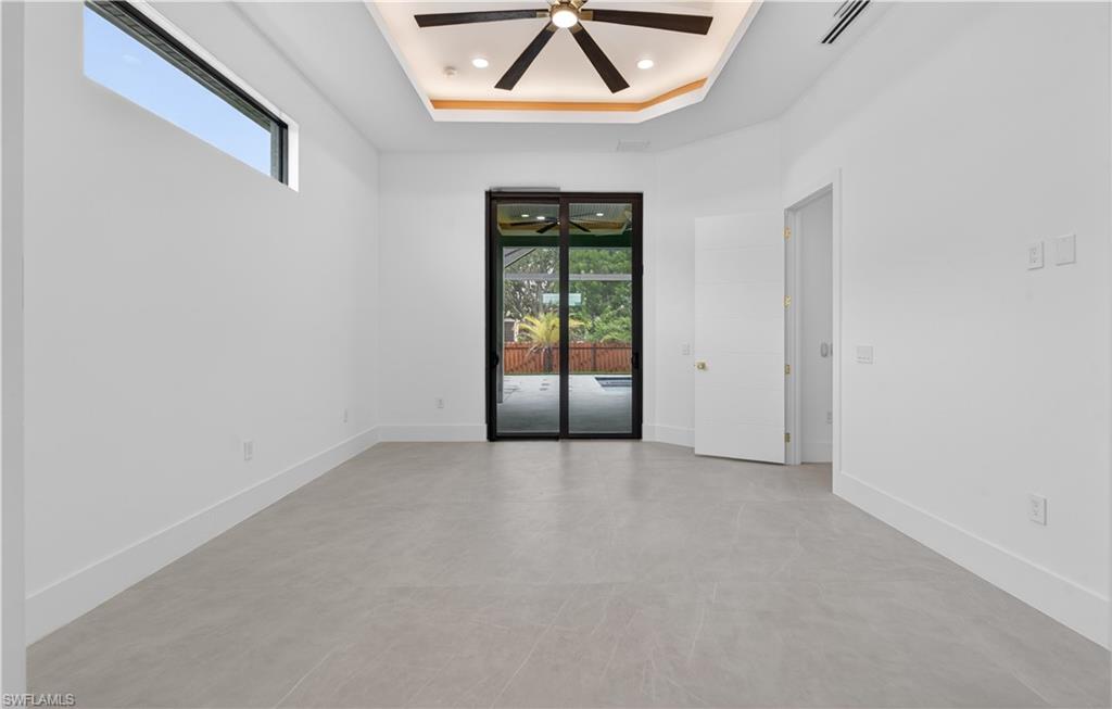 Spacious interior featuring neutral tone flooring, high baseboards, and a contemporary ceiling fan