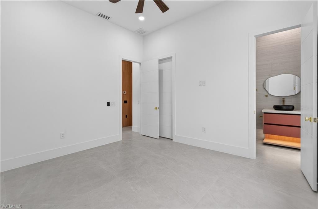 Spacious interior room with light grey tile flooring and bright white walls