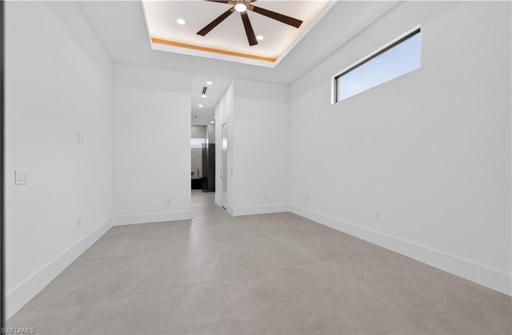 Spacious interior featuring a contemporary ceiling fan, recessed lighting, and a unique clerestory window