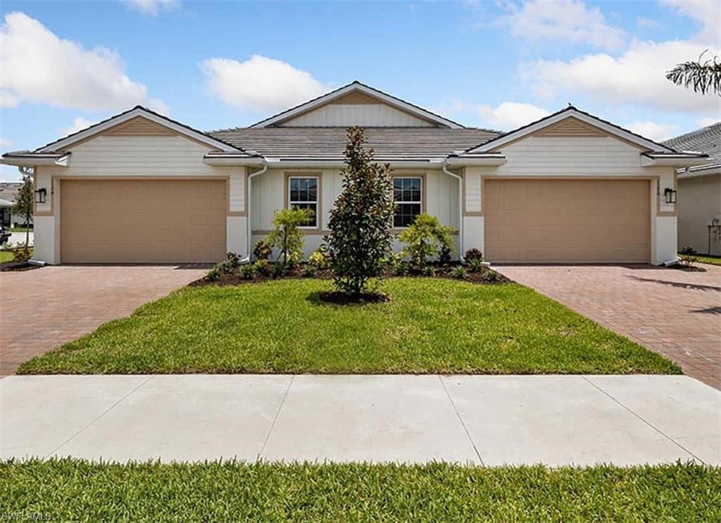 Single story home featuring a garage and a front lawn