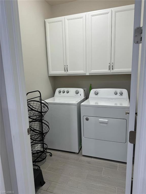 Washroom featuring washer and dryer and cabinets