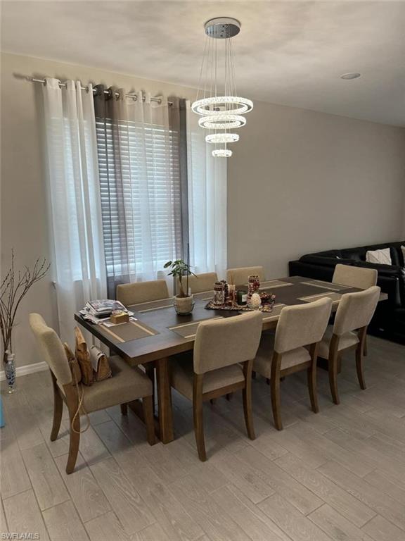 Dining area with an inviting chandelier and light wood-type flooring
