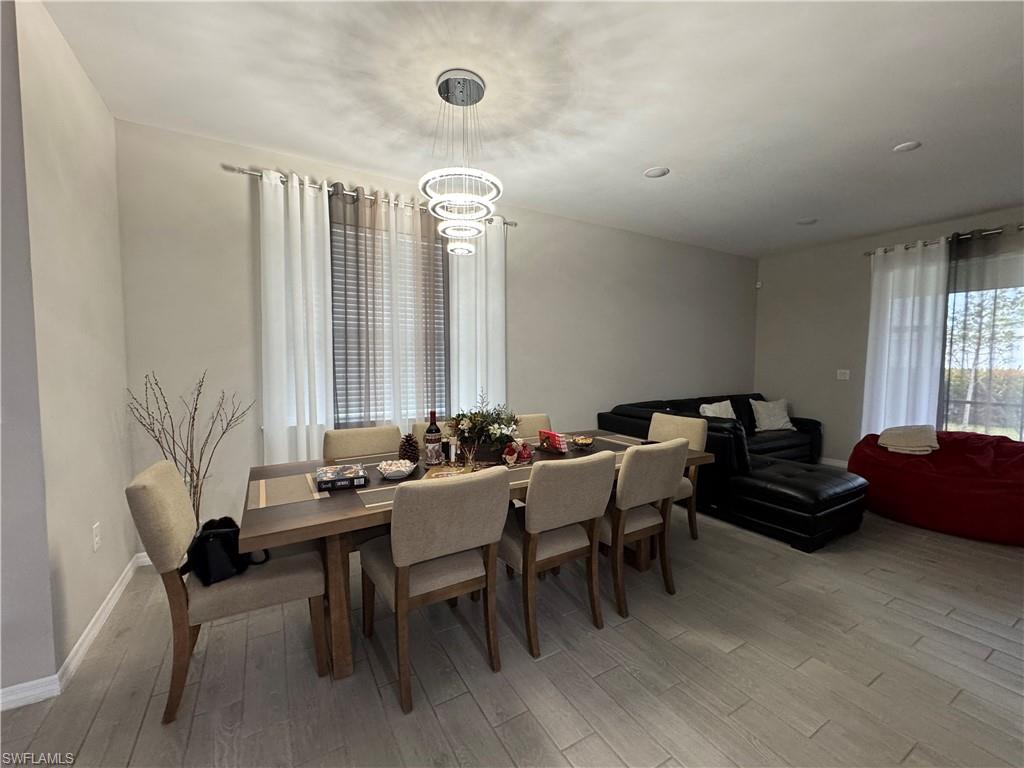 Dining space with an inviting chandelier and light hardwood / wood-style flooring