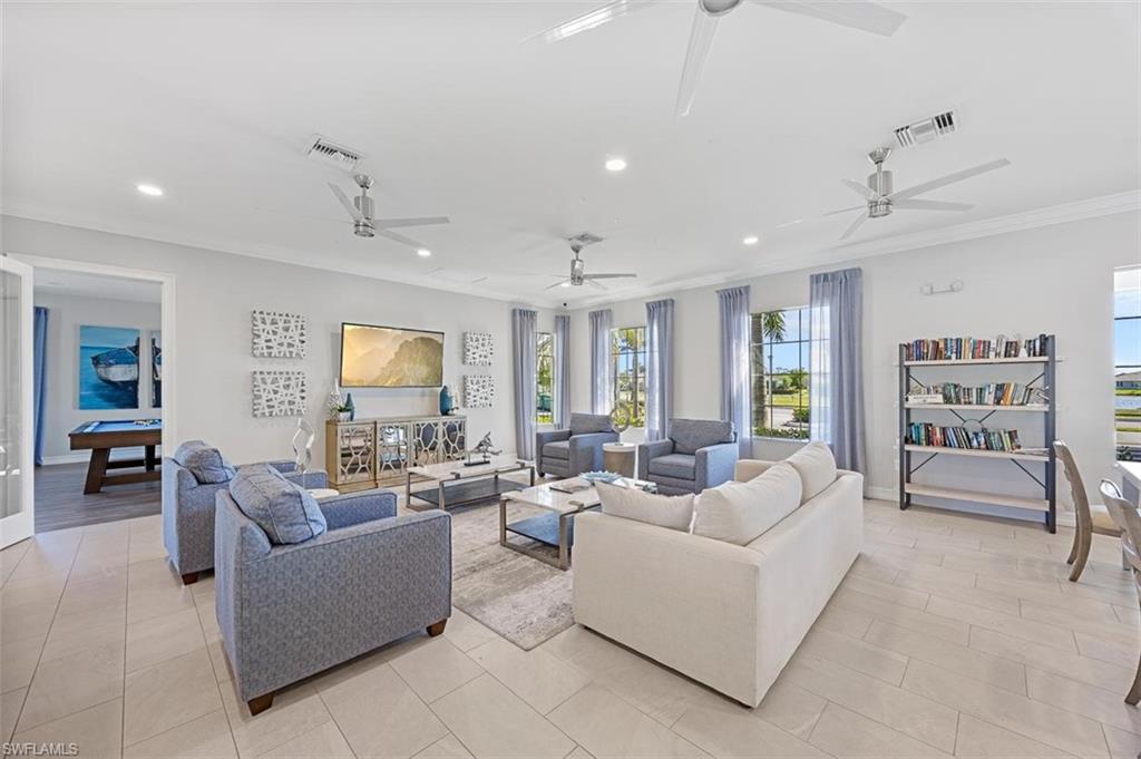 Living room with crown molding and light tile patterned floors