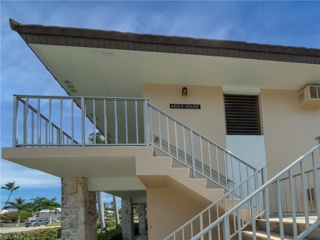 Exterior staircase with metal railings leading to an upper-level balcony