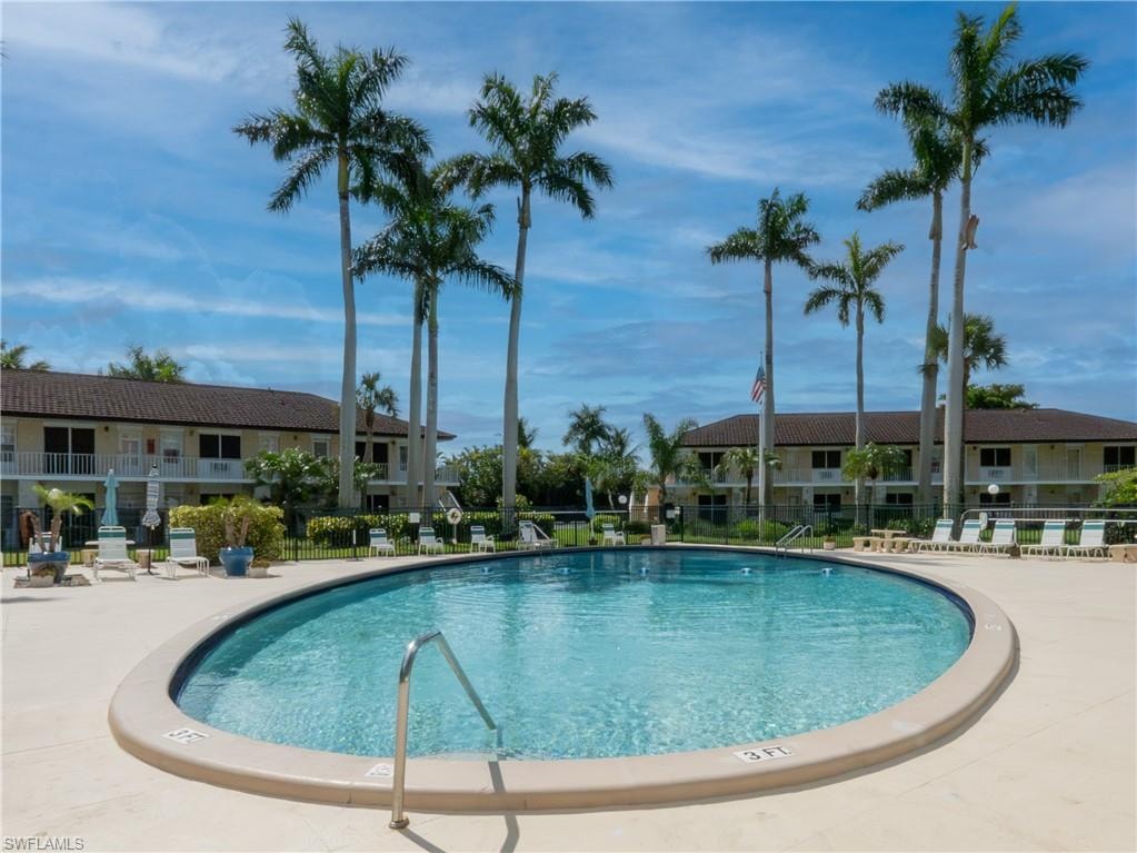 Oval-shaped swimming pool with surrounding deck space, featuring an in-pool handrail and depth markers
