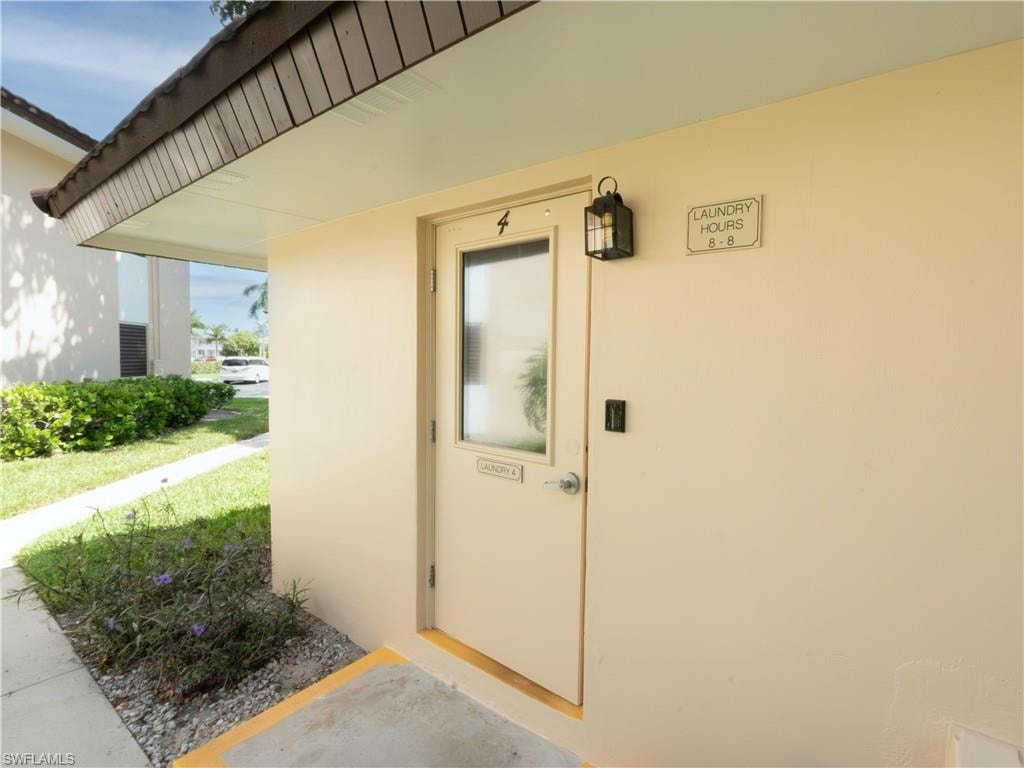 Exterior entry door with a rectangular window panel, flanked by a wall-mounted lantern light fixture