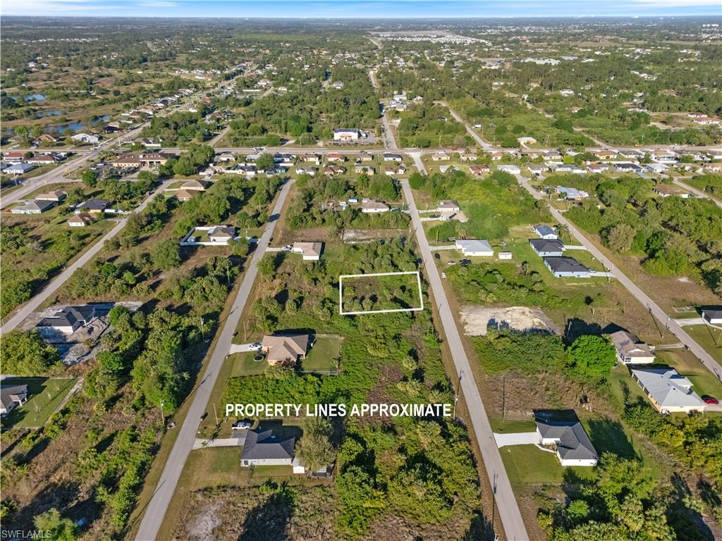 Cleared land parcel surrounded by established residential properties and undeveloped lots