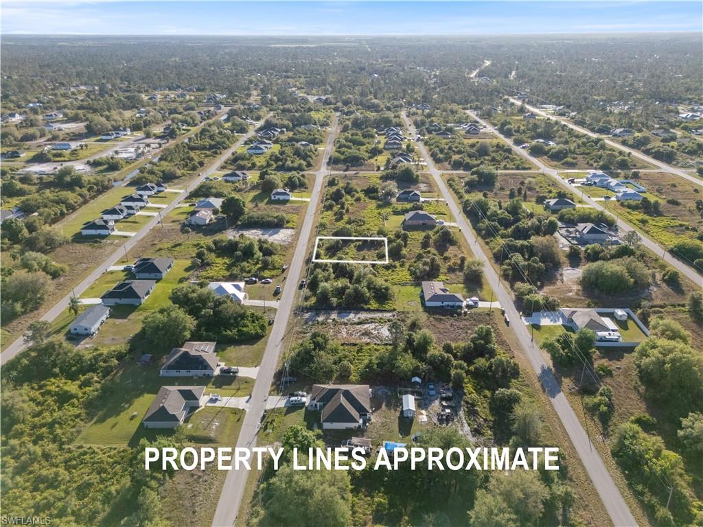 Expansive undeveloped land parcel featuring natural vegetation and surrounding residential properties