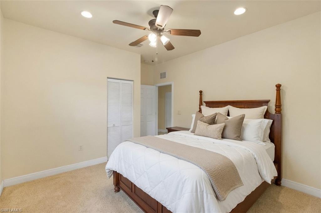 Carpeted room featuring a ceiling fan with integrated lighting, recessed lighting, and a closet with louvered bi-fold doors