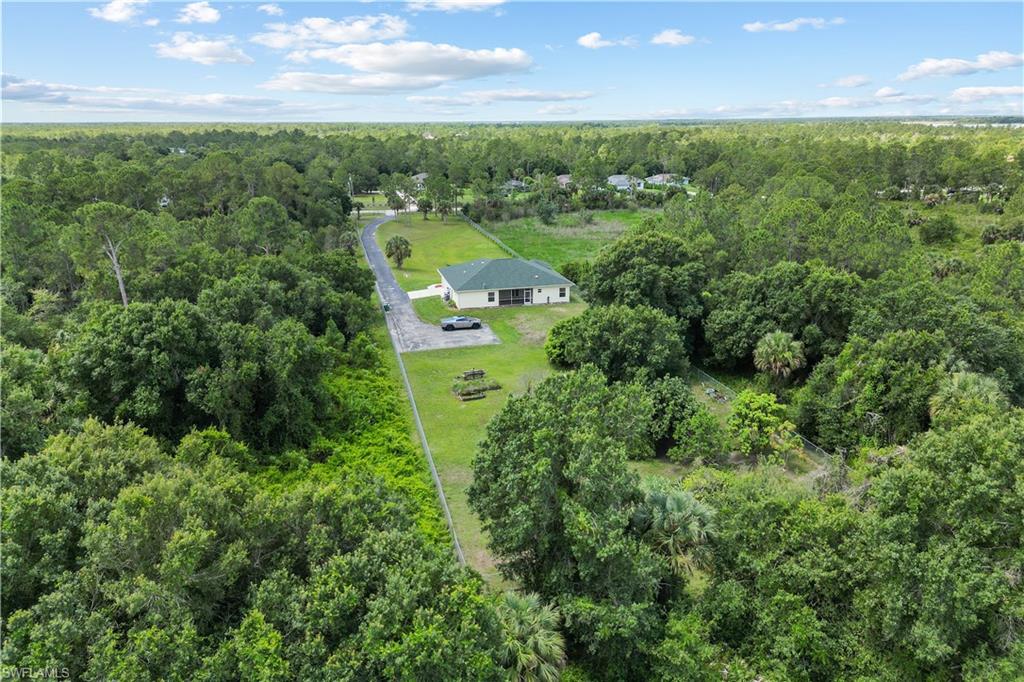 Single-story residence set on a large lot with a paved driveway and mature trees