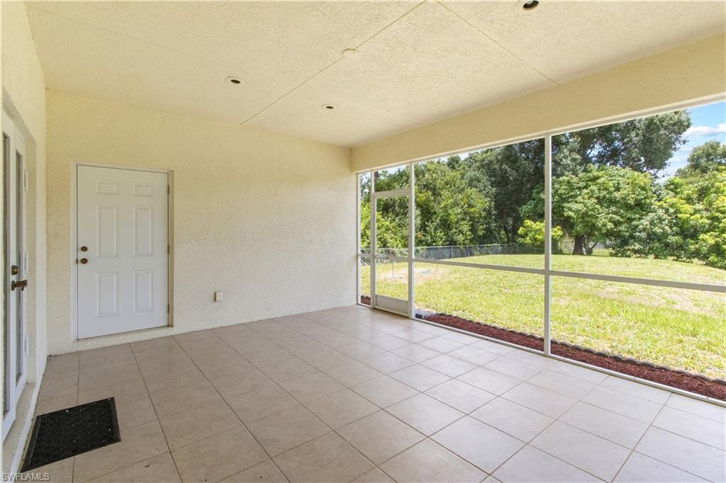 Expansive screened porch featuring neutral-toned tile flooring and textured walls