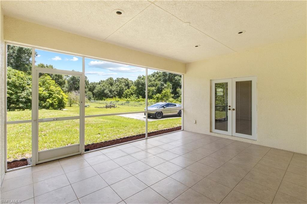 Screened patio featuring large format tile flooring and a textured ceiling with recessed lighting