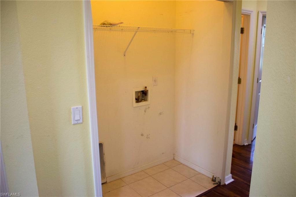 Utility closet with tile flooring and a wire shelf