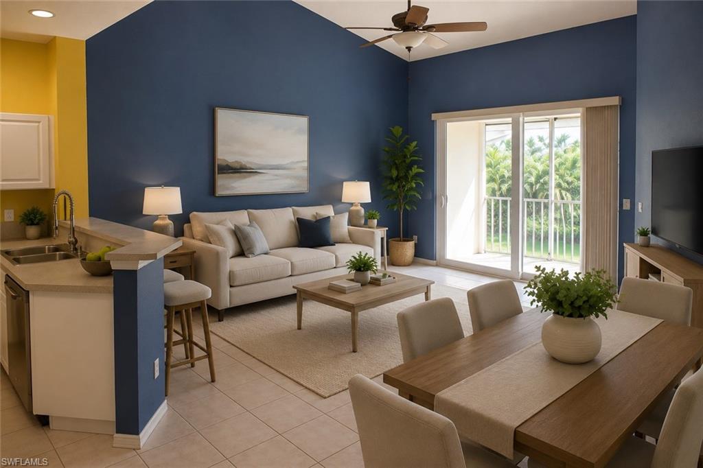 Staged Open-concept living area with vaulted ceilings, sliding glass door access to a balcony, a ceiling fan, and tile flooring