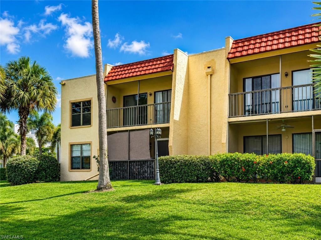 Multi-level property with stucco exterior, red tile roof, and private balconies featuring dark railings