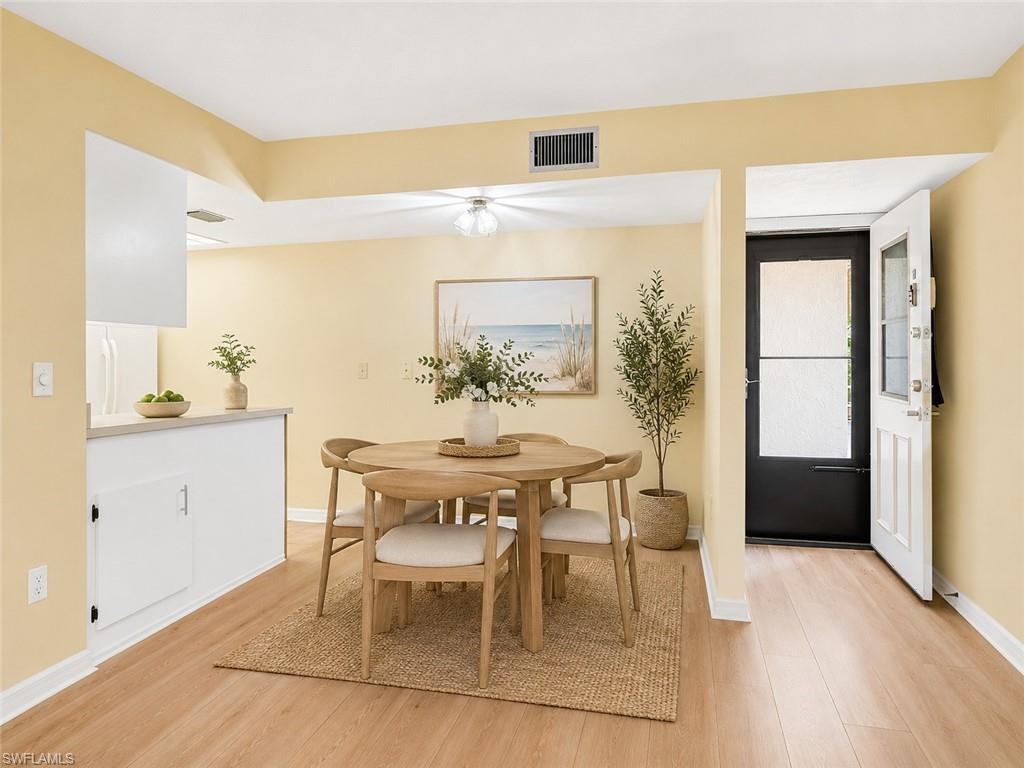 Dining area featuring wood-finish flooring, a contemporary ceiling fan, and a pass-through counter to the kitchen
