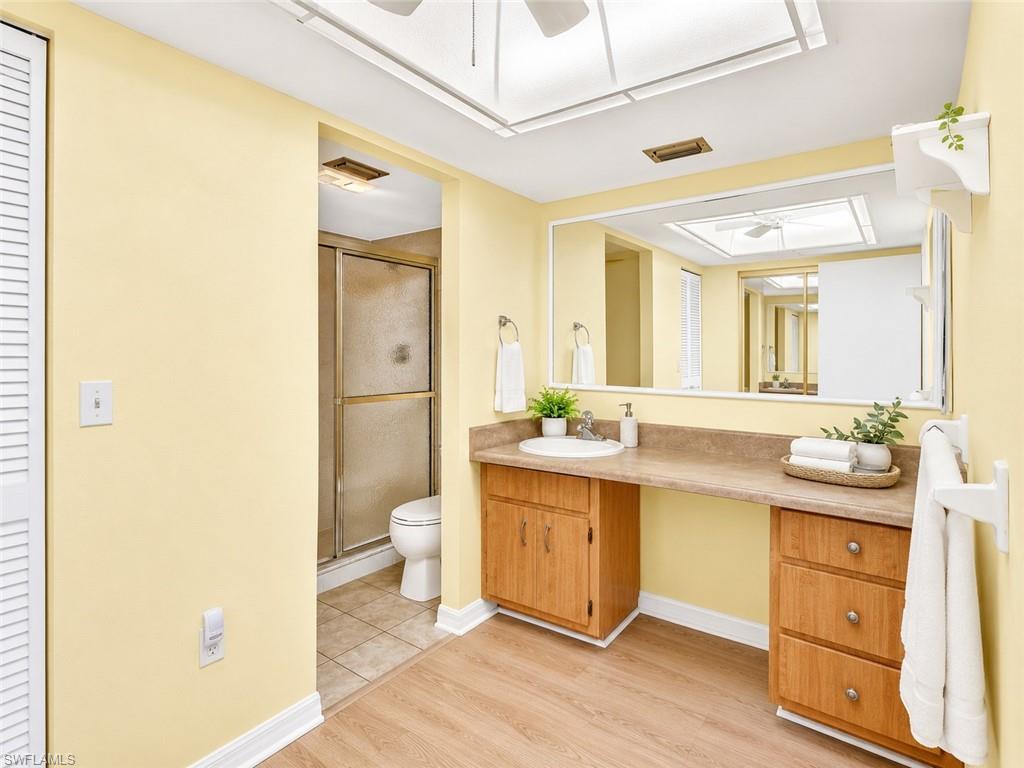Bathroom vanity featuring a single sink, light wood-finish cabinetry, and a spacious countertop