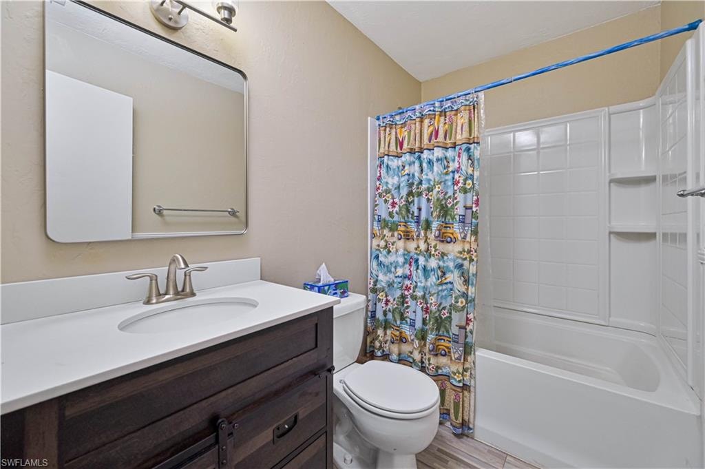 Vanity with single basin sink, brushed nickel faucet, and wood-finish cabinetry