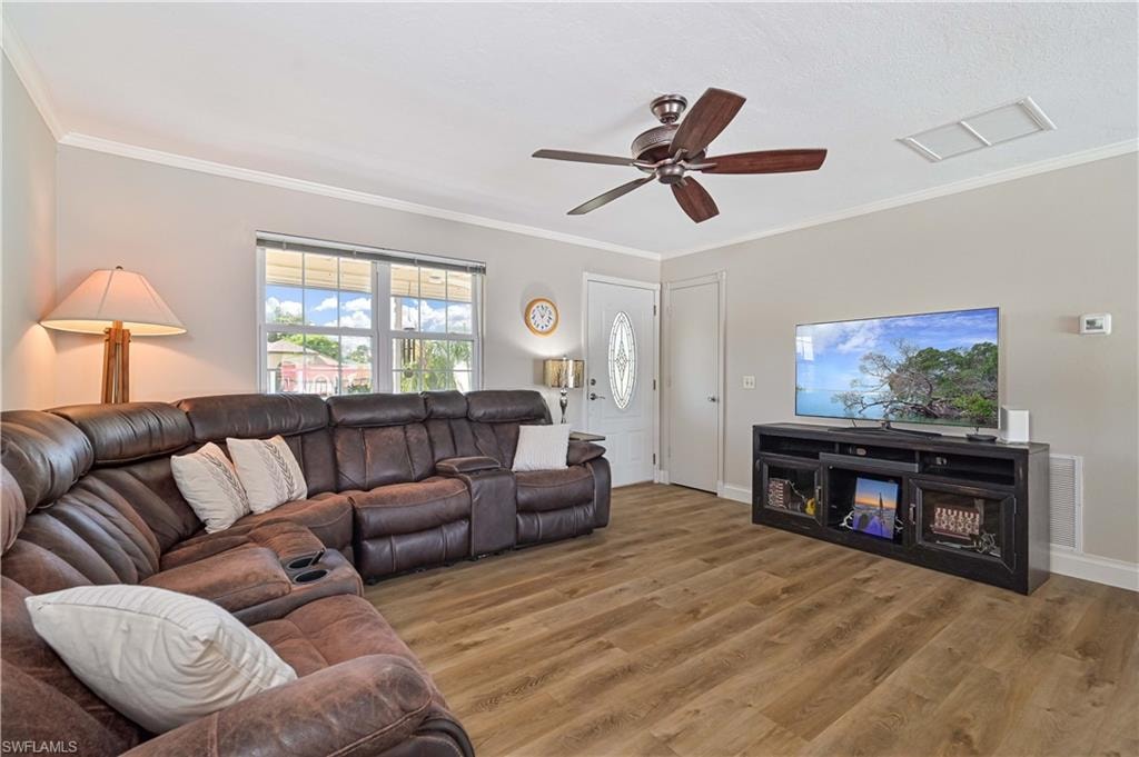 Wood-finish flooring, ceiling fan, white trim, and a window with natural light
