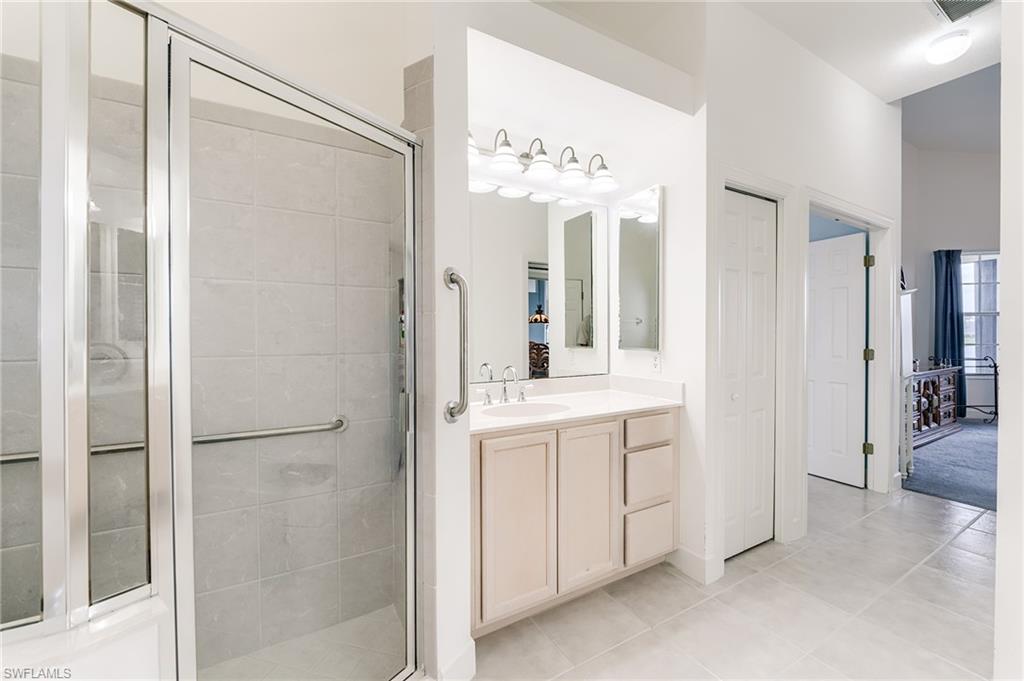 Primary bath with sinks on either side of the soaking tub and shower.  Linen closet to right of sink