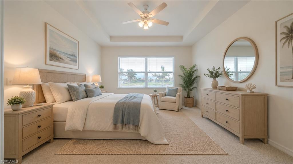 Virtual Spacious bedroom featuring a tray ceiling, ceiling fan with integrated lighting, expansive window, and neutral carpeting