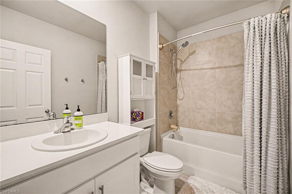 Bathroom featuring a white vanity with an integrated sink, polished chrome faucet, and a large mirror