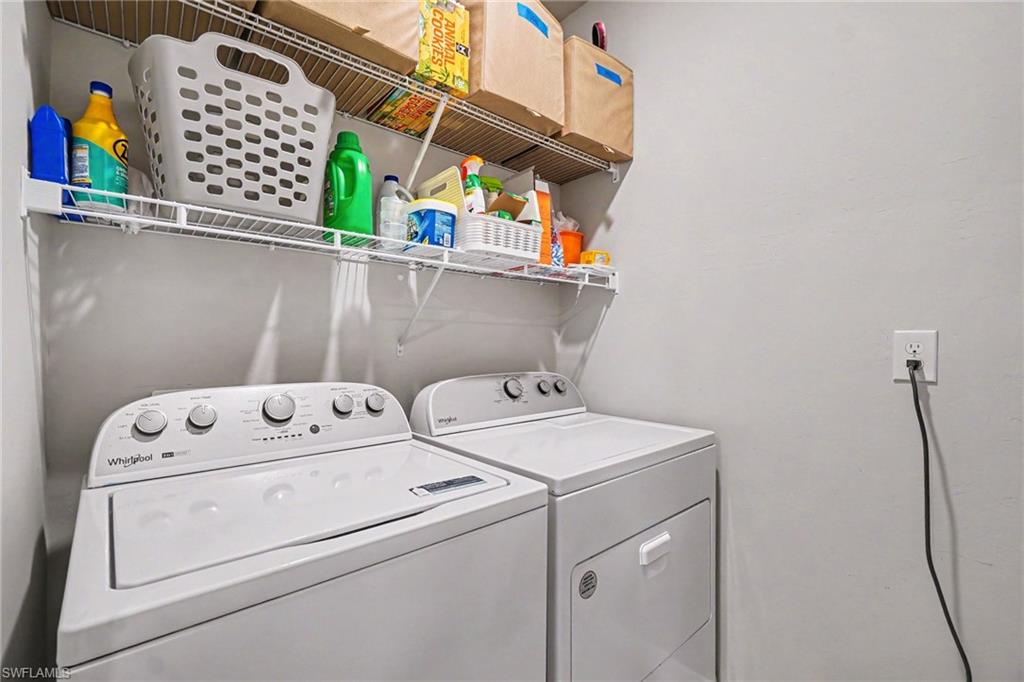 Dedicated laundry area featuring a washer and dryer, complemented by a white wire shelving system for storage