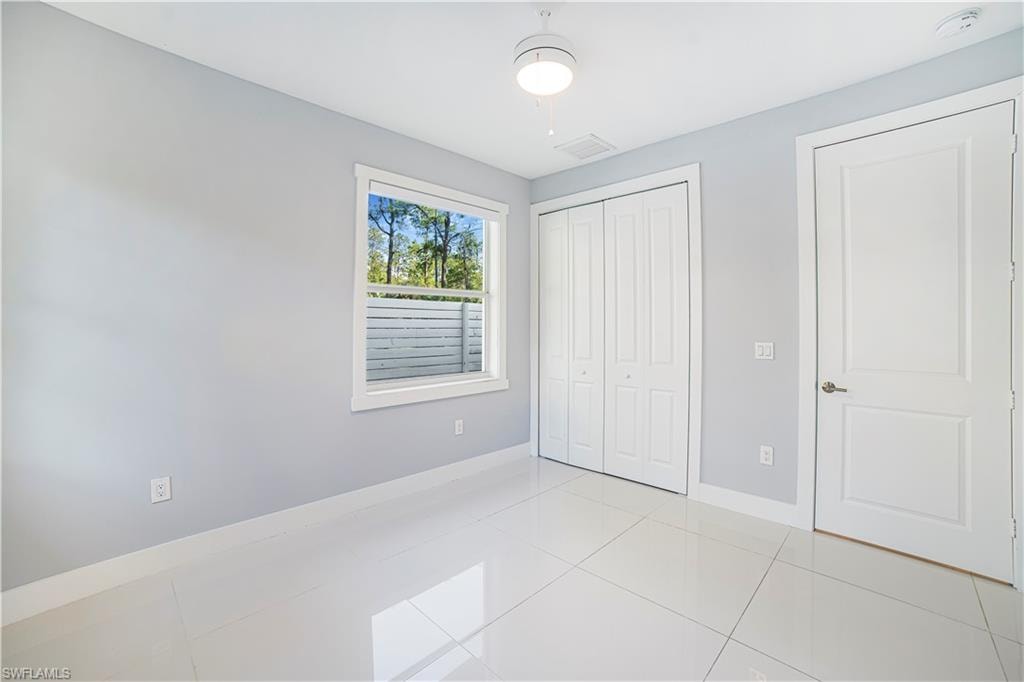 Unfurnished bedroom with a closet, ceiling fan, and light tile patterned floors