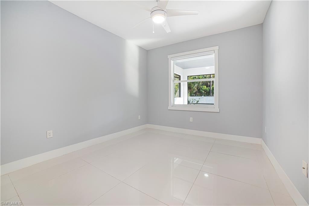 Unfurnished room featuring ceiling fan and tile patterned flooring