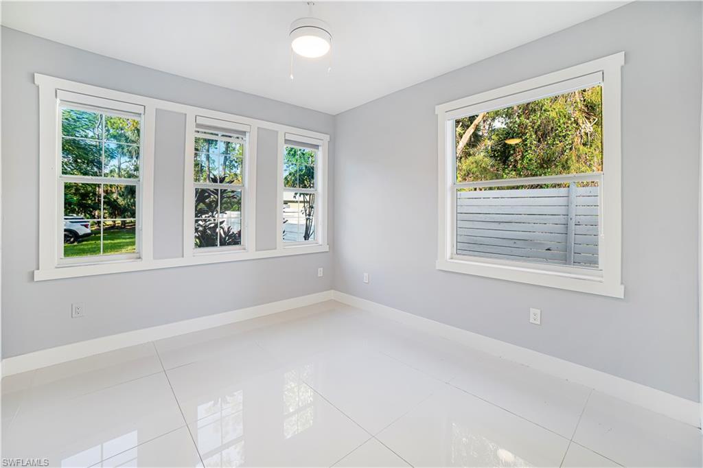 Tiled spare room with a wealth of natural light