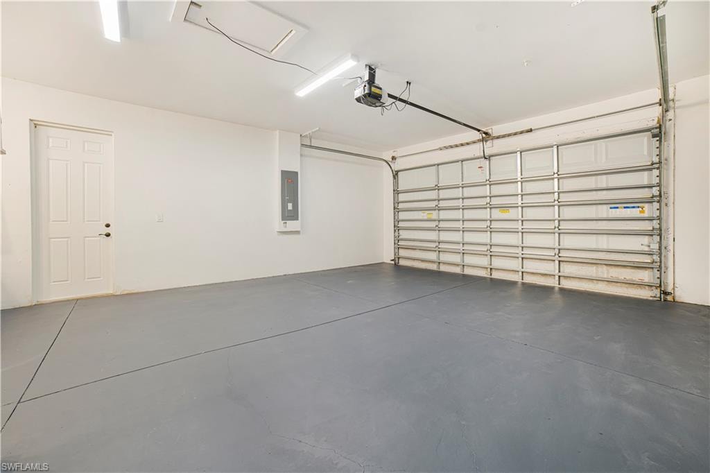 Garage featuring a garage door opener and electric panel
