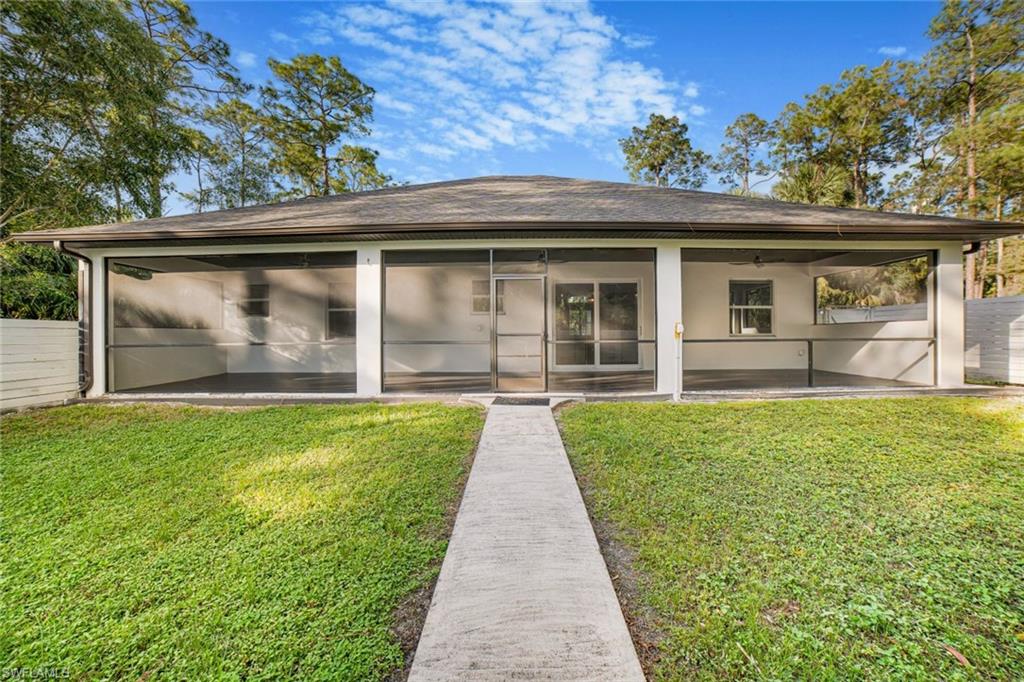 Back of house with a sunroom, a yard, a patio, and ceiling fan
