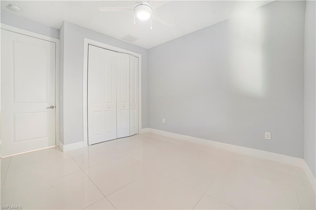 Unfurnished bedroom featuring light tile patterned flooring, a closet, and ceiling fan