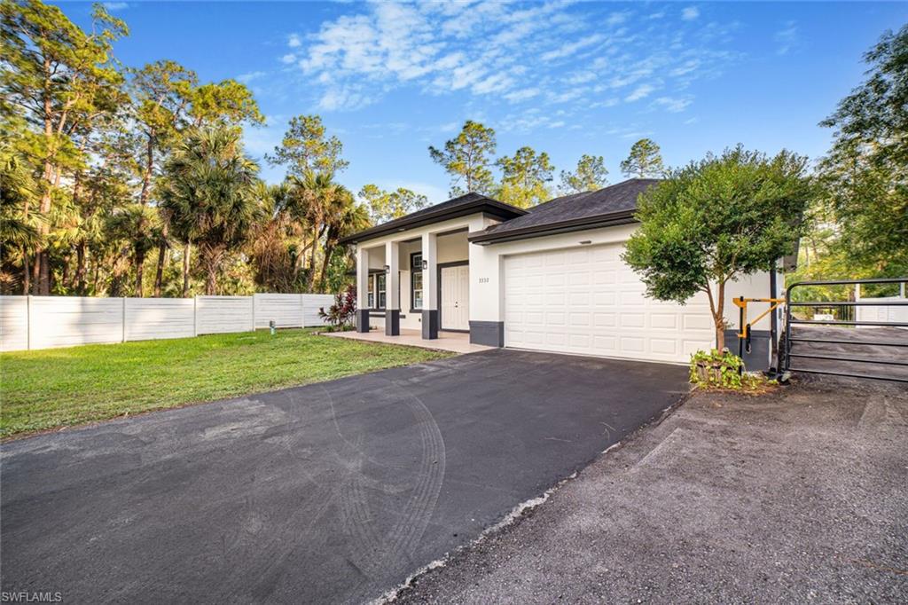 View of front of home with a front yard and a garage